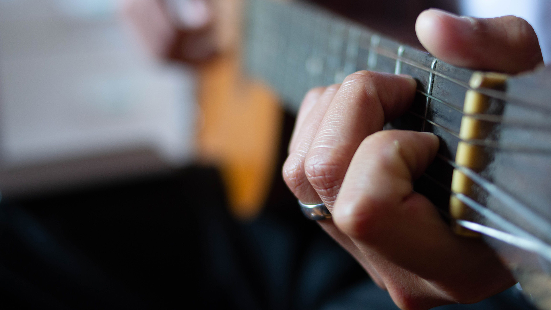 Close-up of beginner hand placement learning guitar chords
